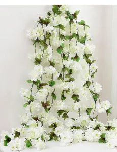 Détail de vignes de fleurs de cerisier blanches artificielles avec feuilles pour la maison.