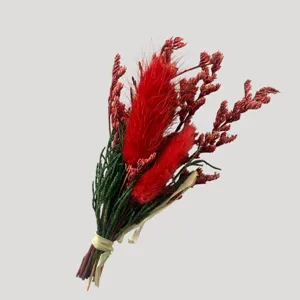 Détail de petit bouquet de fleurs séchées, queues de lapin rouges et feuillage vert cadeau déco.