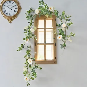Detailed view of artificial eucalyptus and white rose vine on rustic window frame