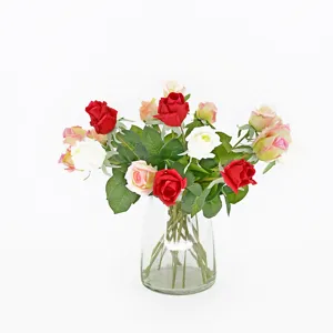 Vista dettagliata di rose artificiali realistiche rosse e bianche in un vaso di vetro