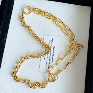 Close-up of vintage gold necklace with asymmetrical Roman and paperclip chain links