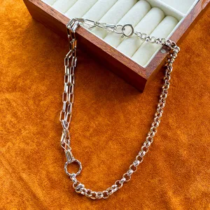Close-up of asymmetric silver chain necklace with rectangular and round links