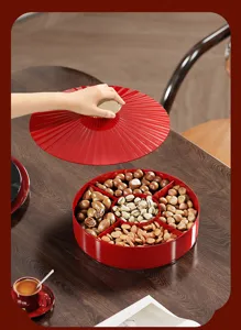 Close-up of a red divided snack tray being opened, showcasing assorted nuts inside
