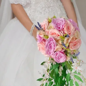 Elegantes Detail eines romantischen Wasserfall-Brautstraußes mit rosa und lila Rosen