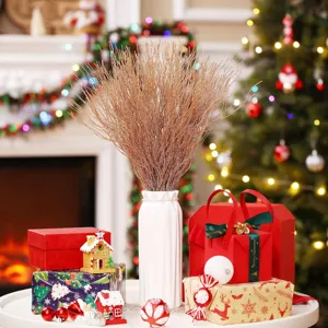 Christmas gold glitter twig branches in white vase with festive gift boxes and tree decor for home.