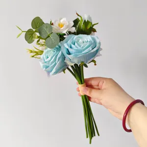 Elegant artificial blue rose and white camellia bridal bouquet held by hand for home decor