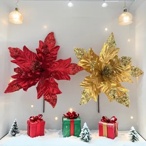 Rote und goldene glitzernde Weihnachtssterne in einer festlichen Schneekulisse ausgestellt