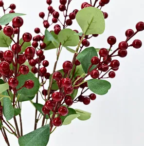Close-up of artificial red berry branches with green eucalyptus leaves for home decor
