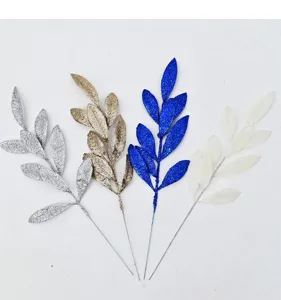 Detailed view of four glittery artificial leaves in silver, gold, blue, and white colors