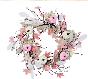 Detail shot of Thanksgiving artificial floral wreath with pink pumpkins and maple leaves.