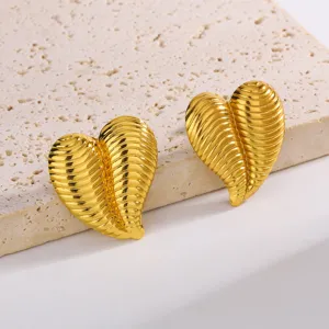 Gros plan détaillé de boucles d'oreilles cœur en or texturé avec motif nervuré élégant