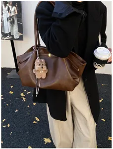 Vista dettagliata di una grande borsa tote marrone vintage con ciondolo a forma di orsetto