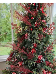 Nahaufnahme von roten Glitzer-Locken-Zweigen und Beeren am Weihnachtsbaum-Dekor.