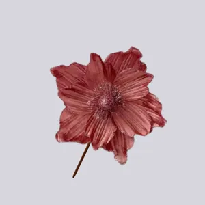 Primo piano di un fiore natalizio artificiale rosa vintage con trama in velluto e glitter.