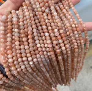 Dettaglio ravvicinato di perle tonde in pietra del sole arancione per gioielli fai-da-te