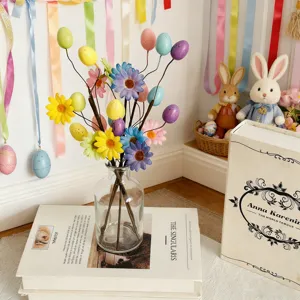 Detailed macro shot of festive Easter speckled egg and daisy floral picks in a clear vase