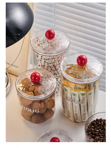 Contenitori trasparenti con pomelli rossi rotondi per chicchi di caffè e frutta secca.