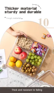 Draufsicht auf transparente geteilte Aufbewahrungsbox mit Früchten und Snacks