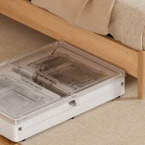 Detailed view of a white foldable storage box with wheels tucked under a wooden bed.