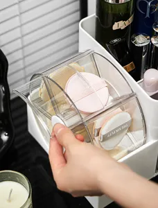 Nahaufnahme einer Hand, die ein staubdichtes Fach im Make-up-Puff-Organizer öffnet.