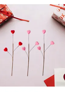 Dettaglio di steli decorativi a tre rami con cuori rossi e rosa per San Valentino