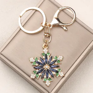 Close-up of snowflake keychain with dark blue rhinestones and gold lobster clasp