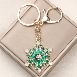 Detailed view of an elegant green rhinestone snowflake keychain with gold alloy finish.