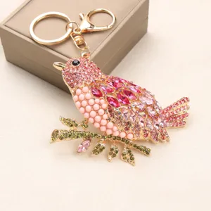 Exquisite detailed view of a heavy rhinestone bird keychain with pink and gold accents