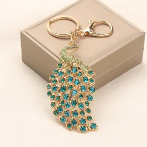 Gedetailleerde weergave van een vintage pauwen-sleutelhanger met blauwe en groene strass