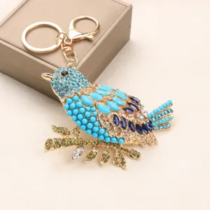 Detailed view of a vintage rhinestone-encrusted magpie bird keychain with gold clasp