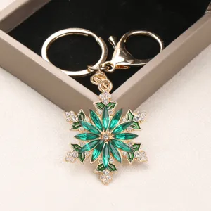 Exquisite gold-plated snowflake keychain featuring green marquise crystals and rhinestones