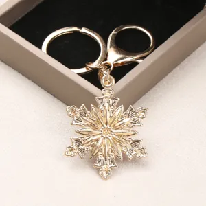 Elegant golden alloy snowflake keychain with intricate rhinestone detailing for bags