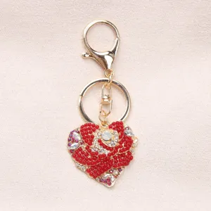 Close-up of heart-shaped keychain with red rhinestone rose and gold clasp