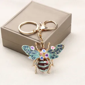 Nahaufnahme eines Retro-Bienen-Schlüsselanhängers mit Emaille-Blumen und Strass.