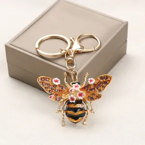 Detailaufnahme eines Vintage-Bienen-Schlüsselanhängers mit rosa Blumen