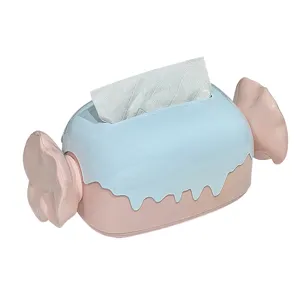 Caja de pañuelos con forma de caramelo en azul y rosa pastel para decoración del hogar.