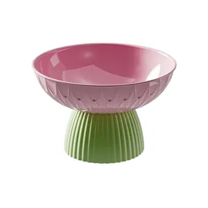 Frutero decorativo estilo dopamina con pie alto en colores rosa y verde vibrantes