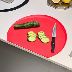 Red TPU D-shaped non-slip cutting board for kitchen use featuring a semi-circular design