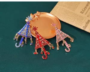 Detailansicht von drei Vintage-Strass-Schirmbroschen in Blau, Rot und Rosa für Damen.