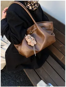 Grande borsa tote vintage marrone in ecopelle indossata a spalla in un contesto casual