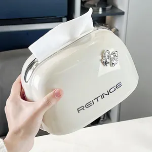 Elegant creamy white glossy tissue box holder with decorative silver bow and brand logo