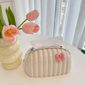 Vintage pleated tissue box with a pink bow decoration on a white table