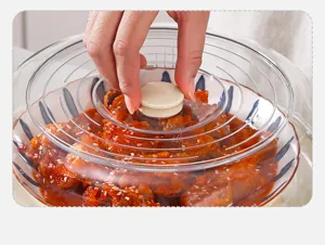 Primer plano de una mano sosteniendo el pomo de una cubierta plástica transparente para alimentos