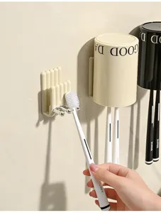 Primo piano di portaspazzolino da parete in stile crema e bicchiere invertito