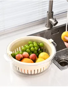 Close-up of double-layer rotating drain basket with fresh fruits in a kitchen sink
