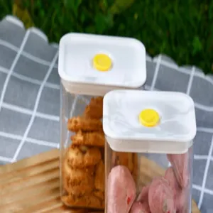 Close-up of airtight plastic food containers with yellow vacuum valves on picnic cloth