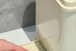 Macro view of the functional pull-out bottom tray on a cream kitchen seasoning organizer