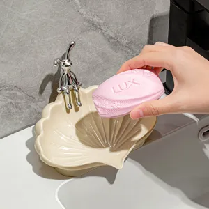 Elegant shell-shaped soap dish with silver rabbit figurine, ideal for bathroom drainage