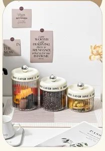 Set of three transparent fluted plastic canisters with cream lids and silver knobs