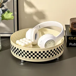 Modern cream-colored rotating storage tray with a black and white checkerboard pattern
